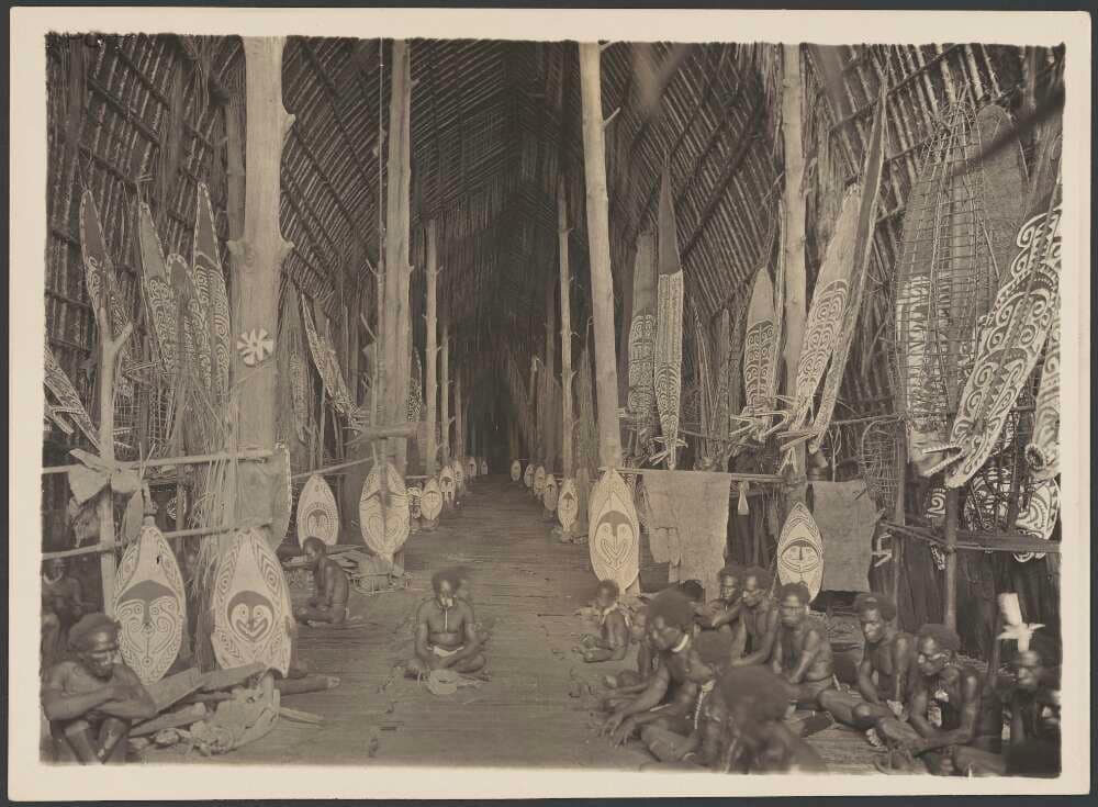 The interior of a longhouse in Kaimari village on Urama island in the Gulf of Papua, circa 1922. Note the spirits boards at the entrance of each family's partition. Although considered 'primitive' to some, people in the Gulf of Papua made longhouses that could be longer than a football field.
Image credit: Frank Hurly, circa 1922.