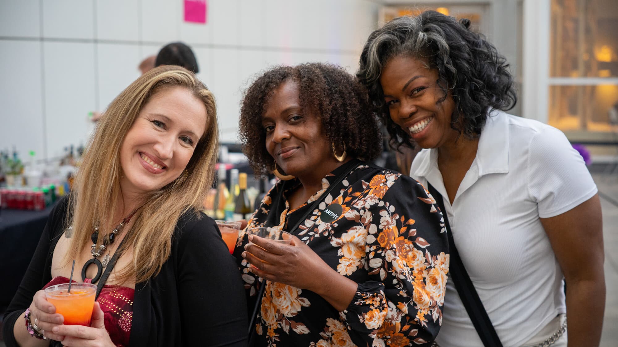 Three women with cocktails at ArtMix